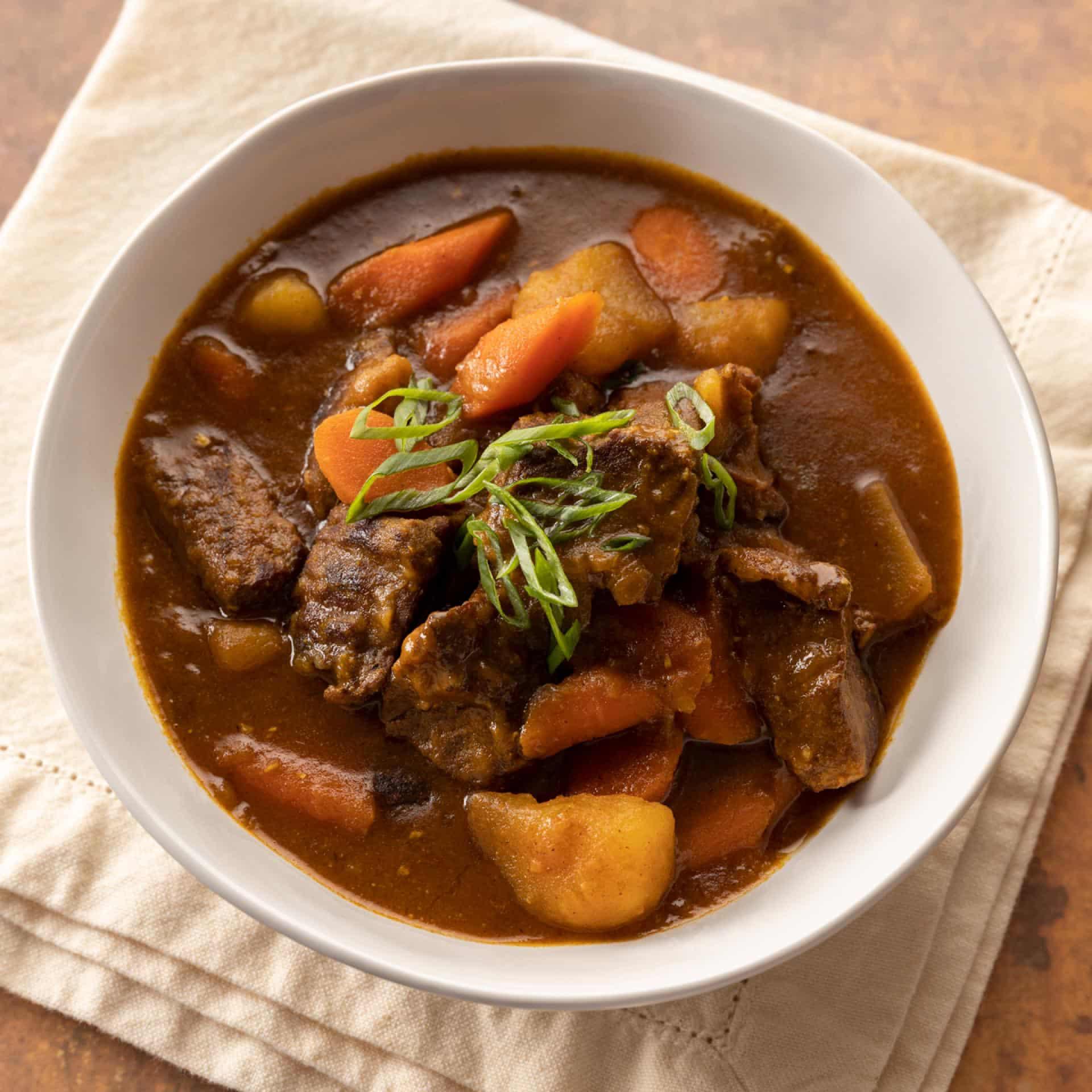 Top down image of a bowl of Japanese beef curry sitting on a cloth napkin